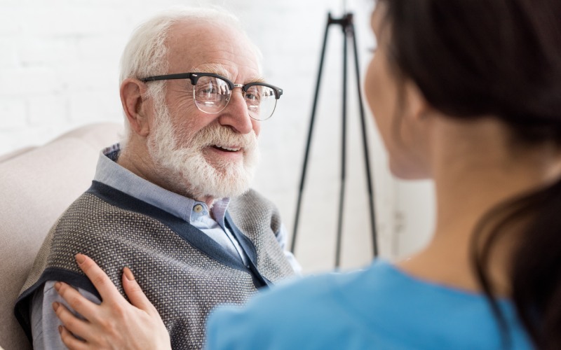 selective focus cheerful grey haired man looking nurse