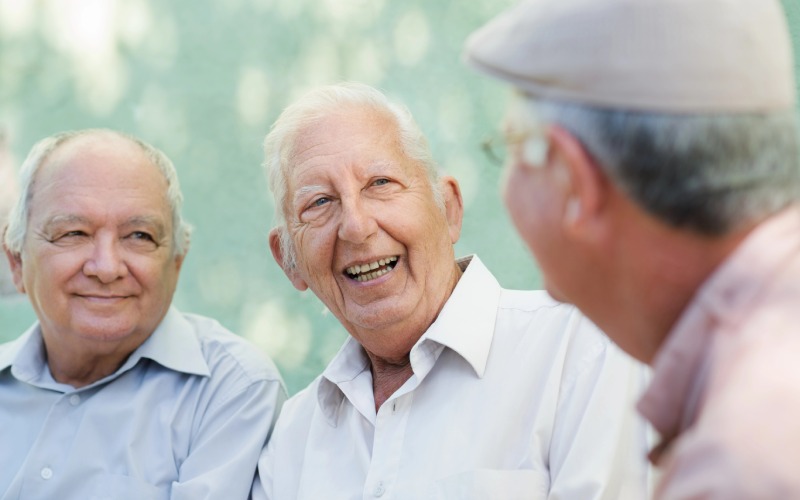 group of happy elderly men laughing and talking