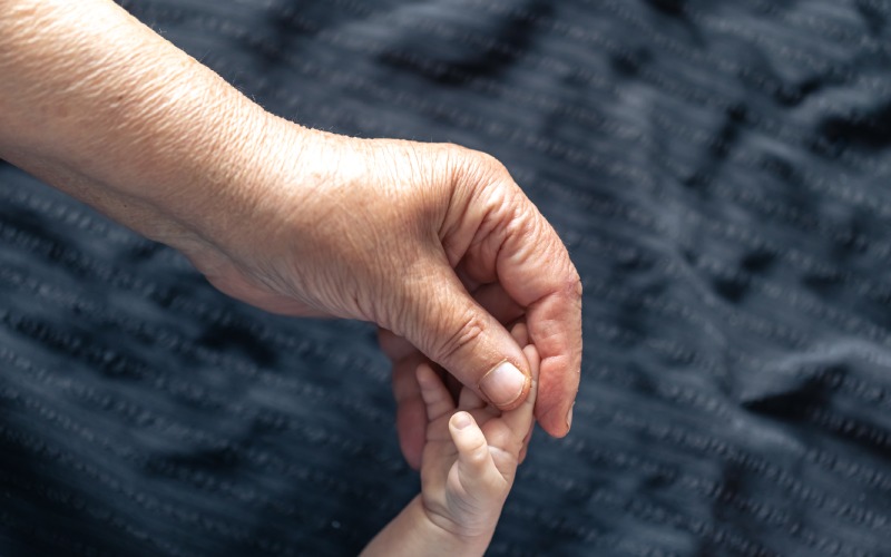 hands senior person little baby
